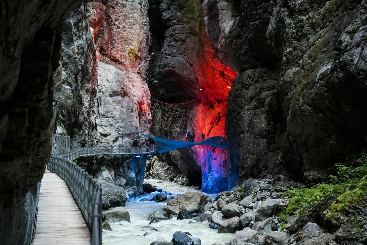 a bridge in a cave with a colorful wall