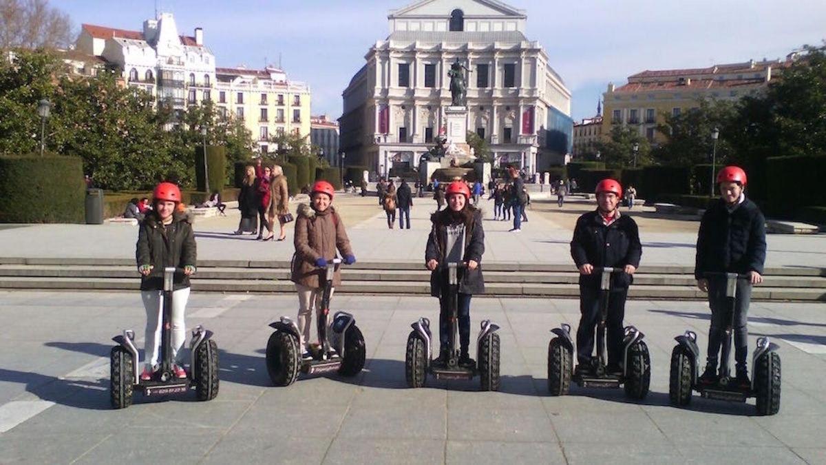 a group of people riding on segway se vehicles