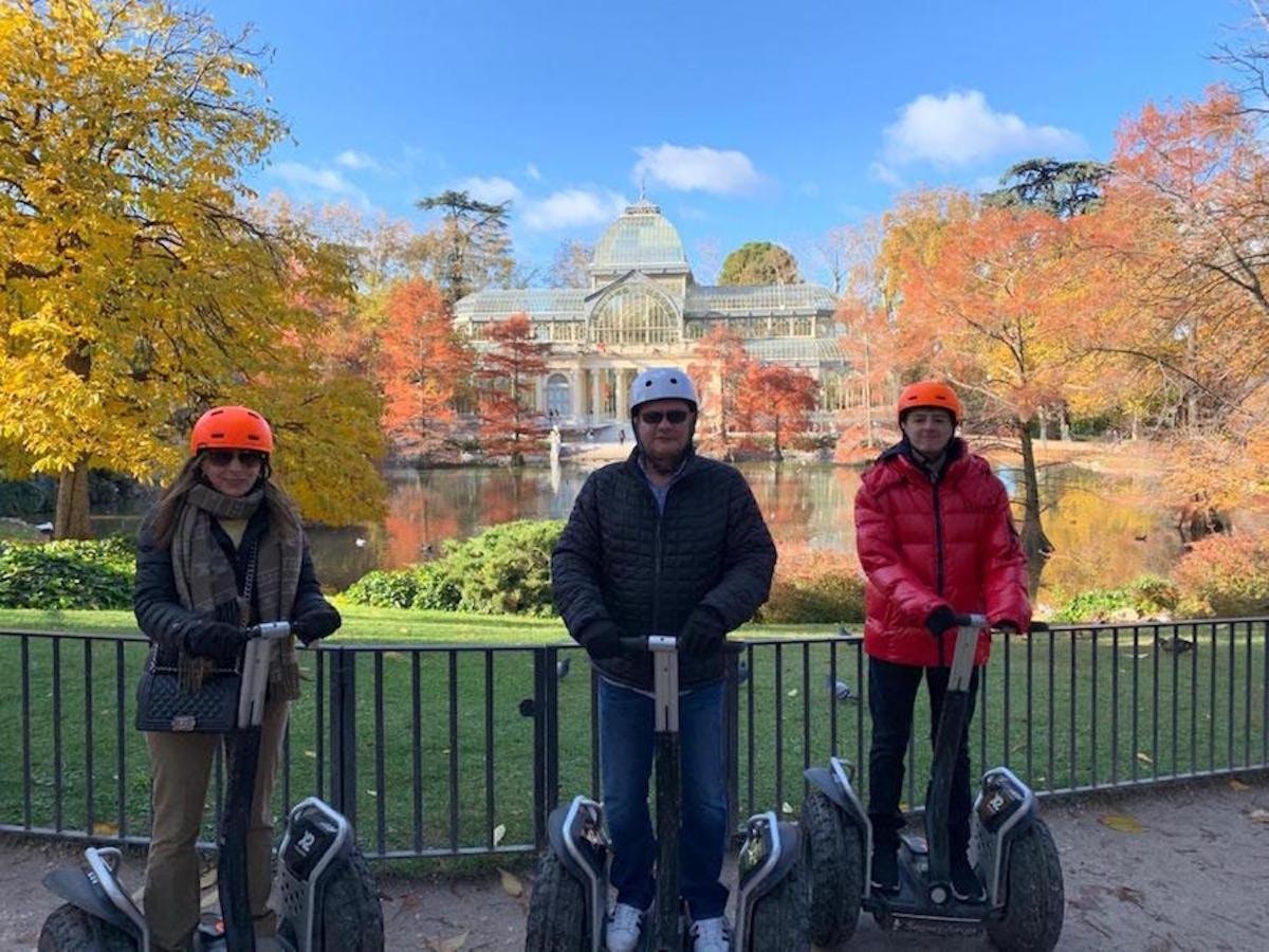a group of three people riding on segways in front of a park
