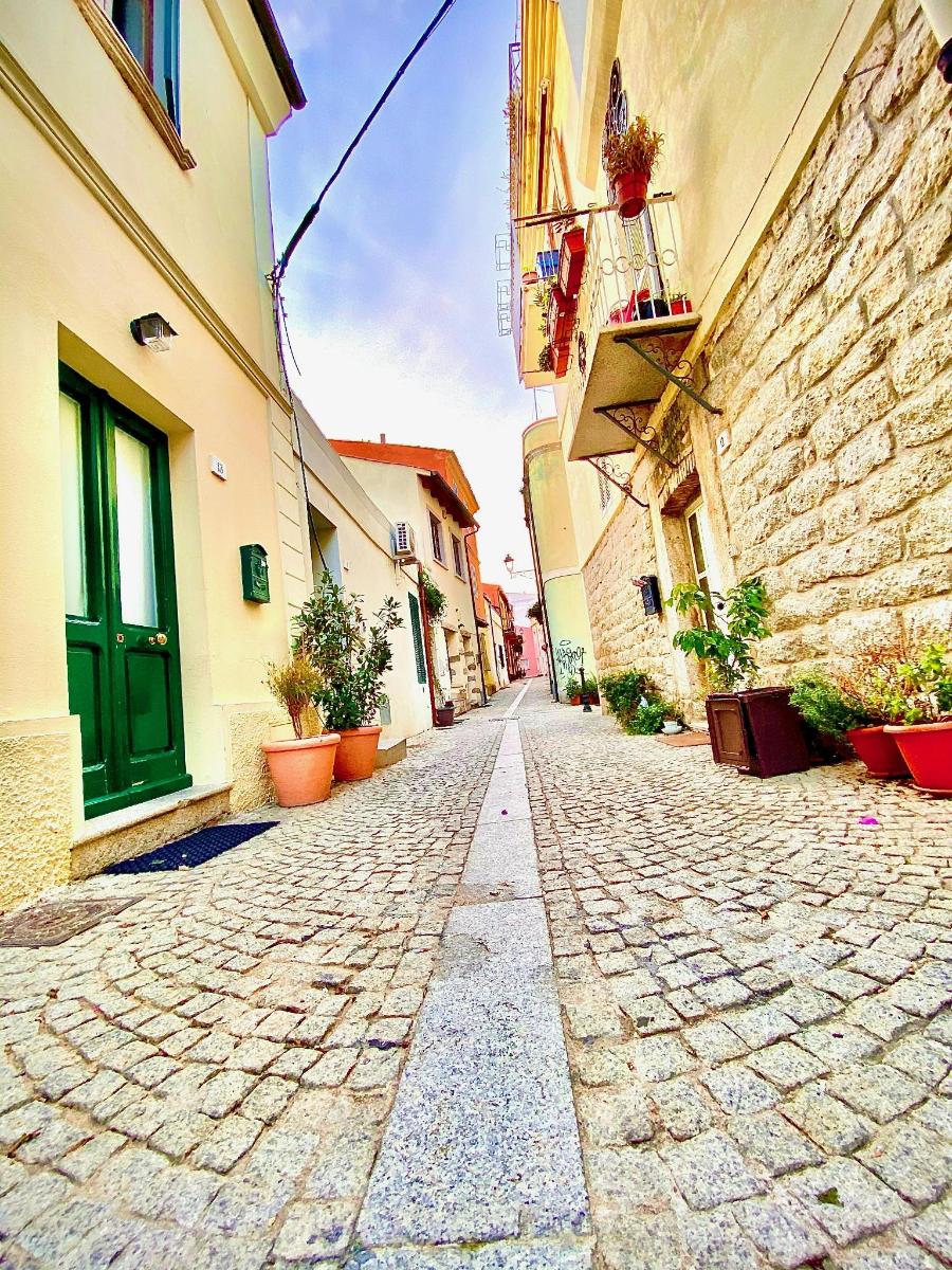 una strada acciottolata con edifici e una porta verde