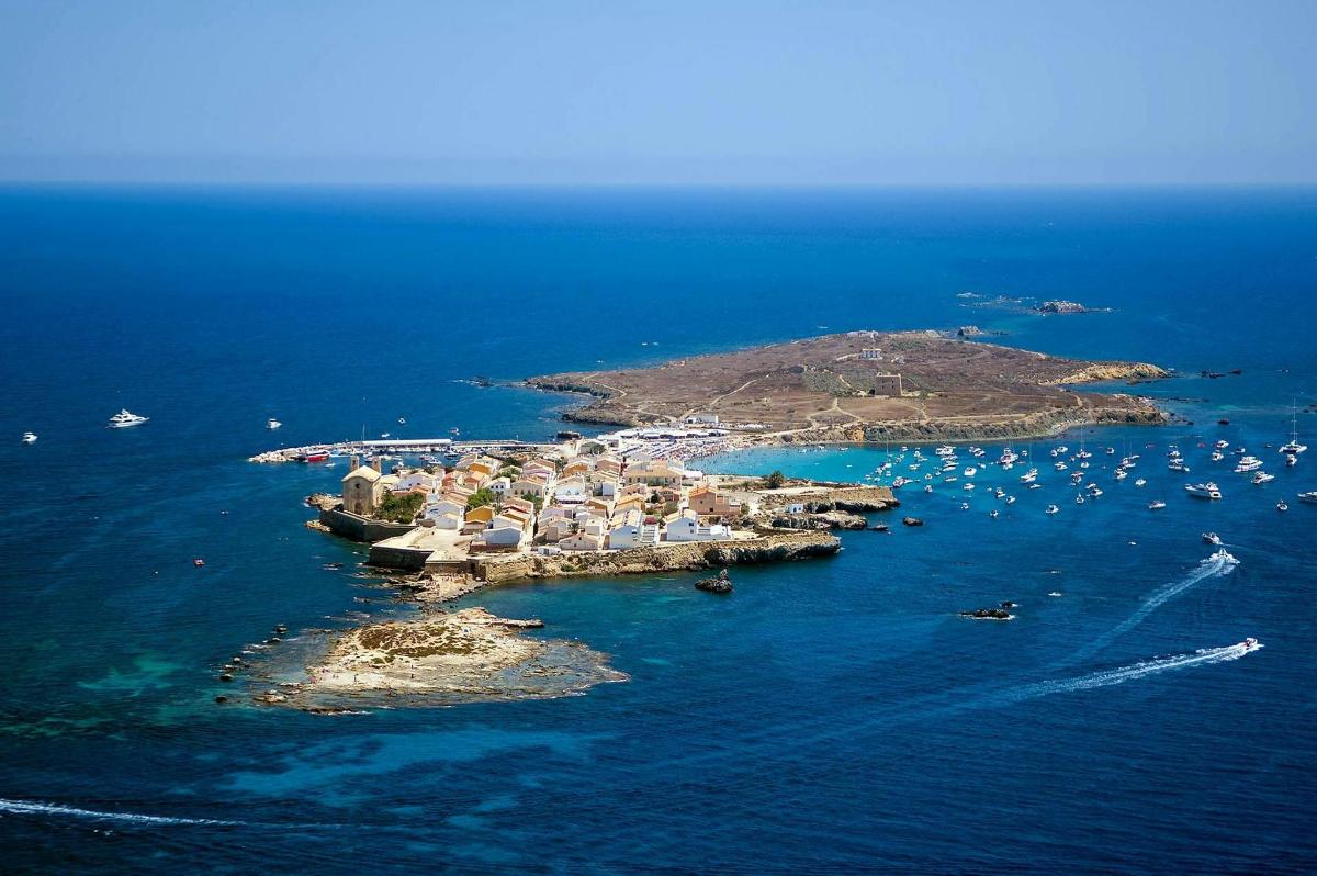 an island in the ocean with boats in the water