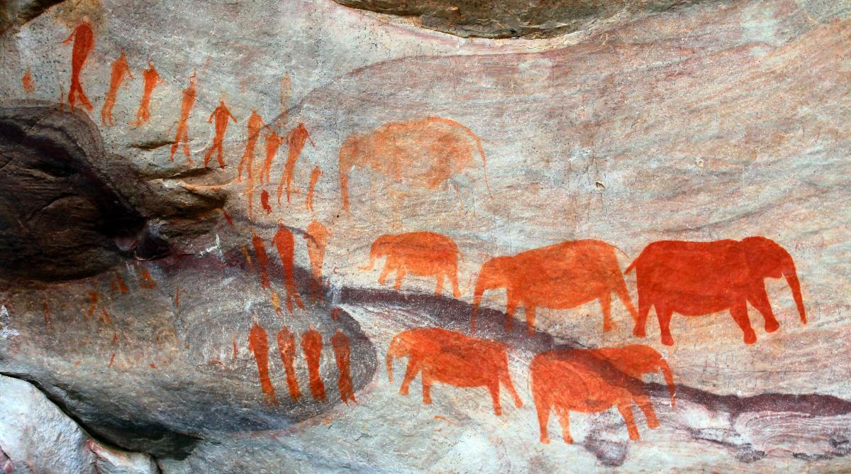 a painting of a group of animals on a rock wall