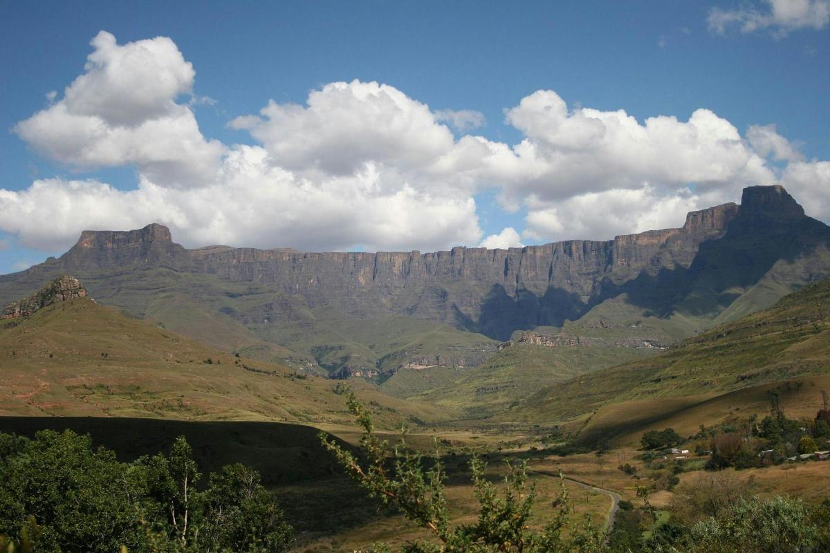 a view of a mountain range with green hills
