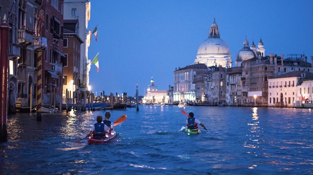 un gruppo di persone che navigano in kayak su un canale