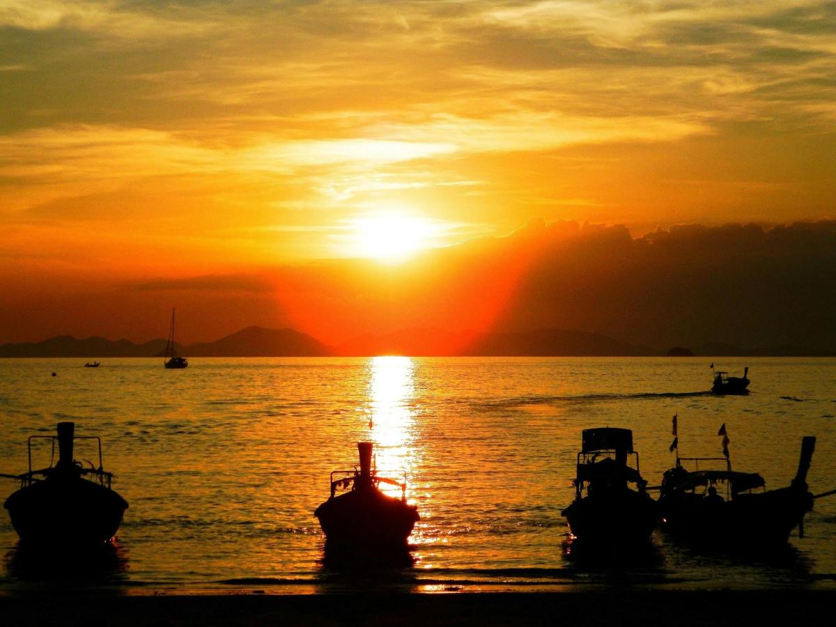 a group of boats in the water at sunset