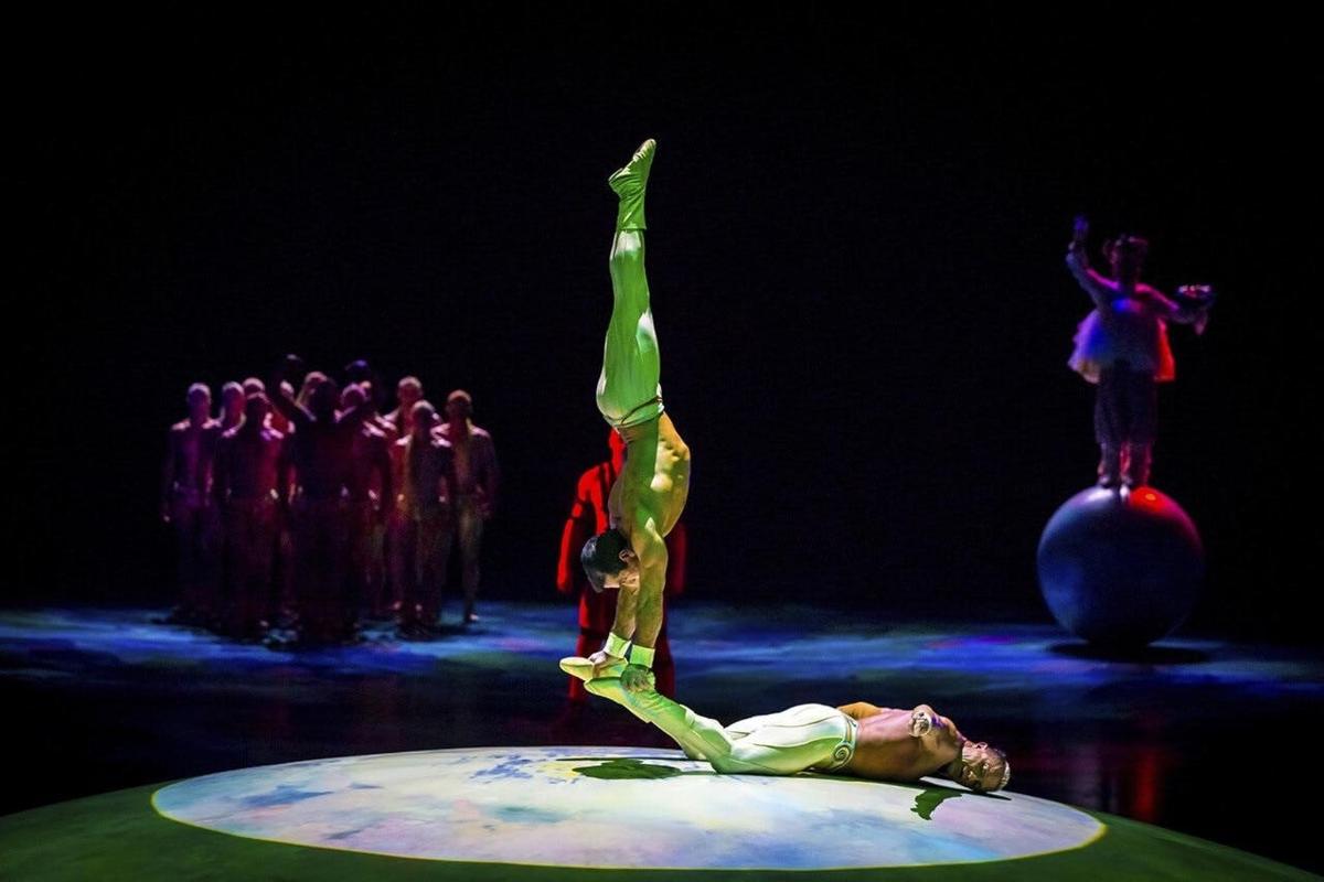 a woman on a stage with her arms in the air