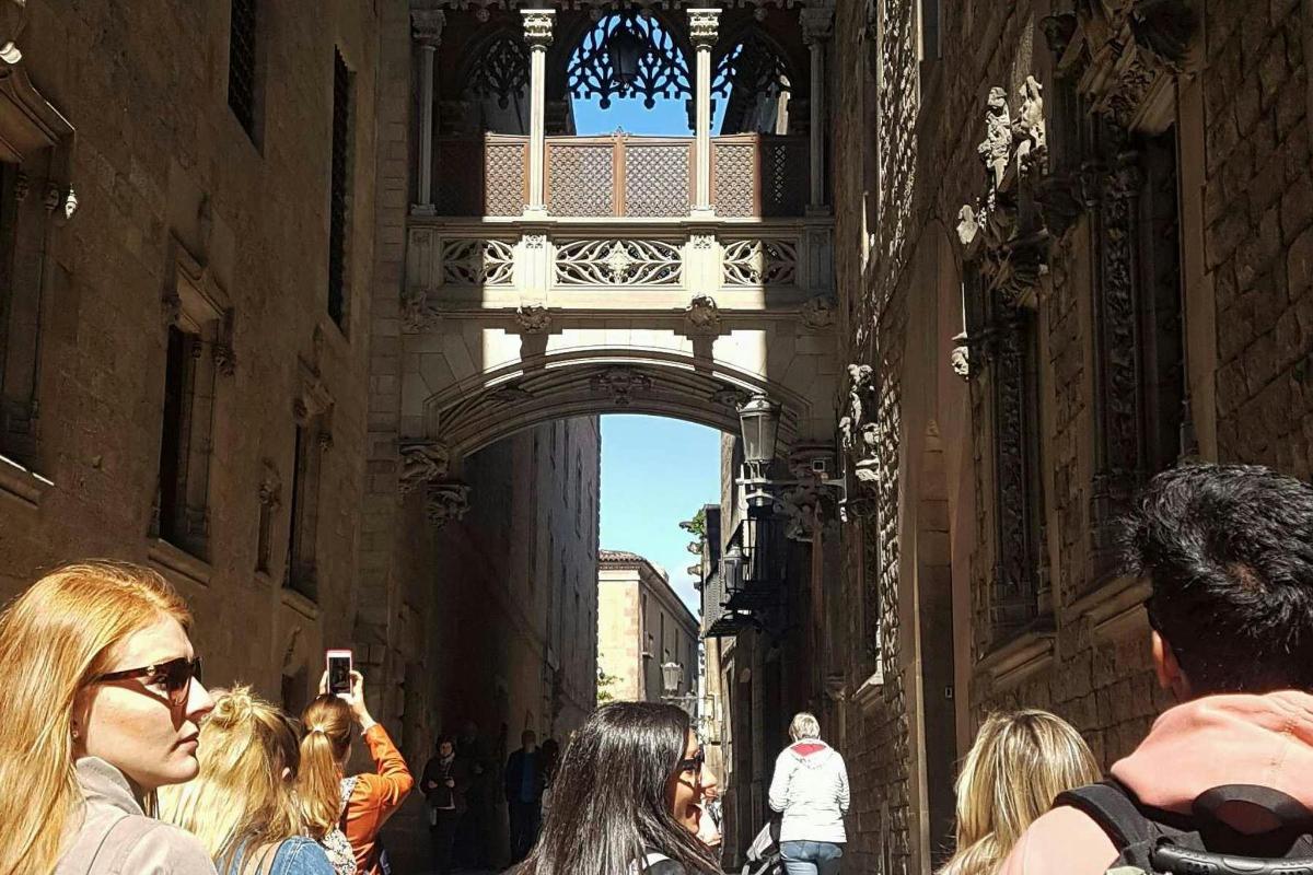 un gruppo di persone che camminano lungo una strada sotto un arco