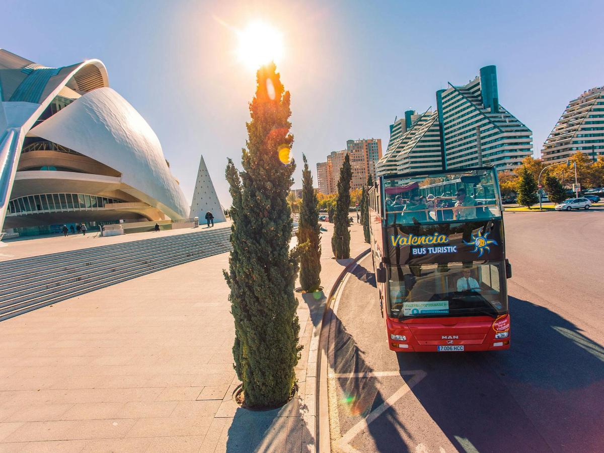 un autobús vermell de dos pisos passant per davant d'un edifici