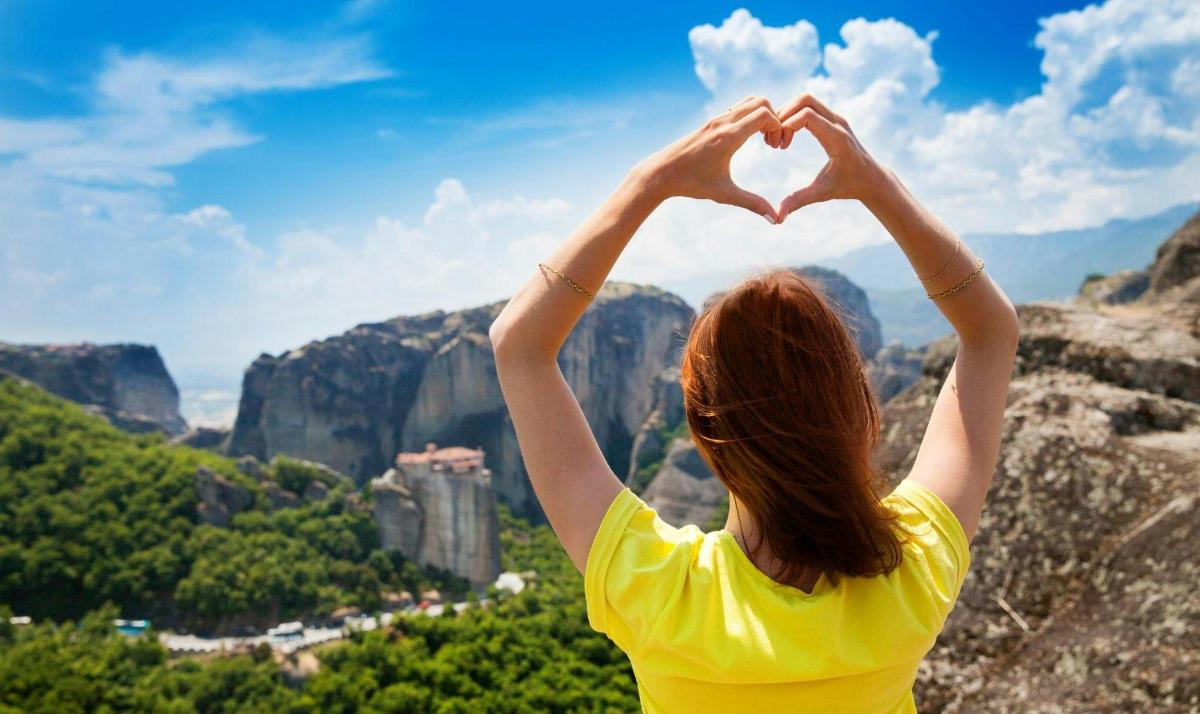 Una mujer haciendo forma de corazón con sus manos.
