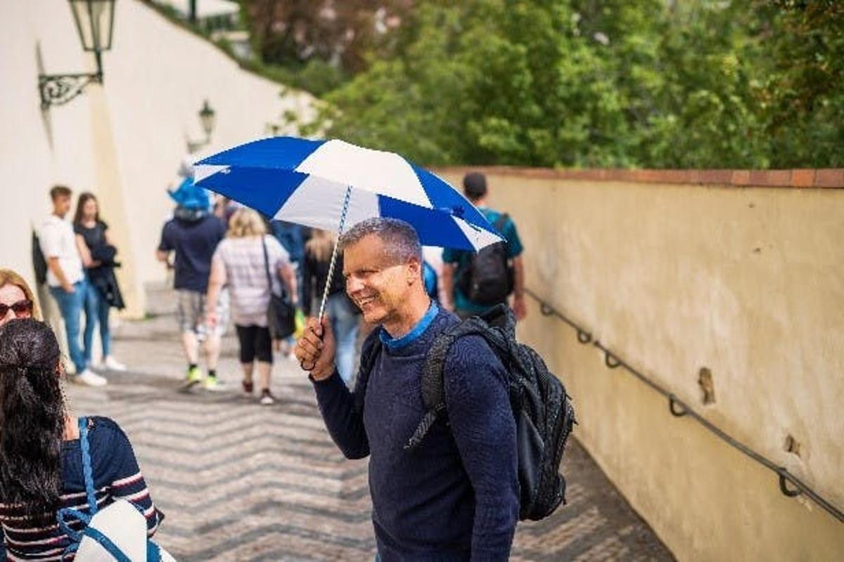 maður sem heldur á bláum og hvítum regnhlíf