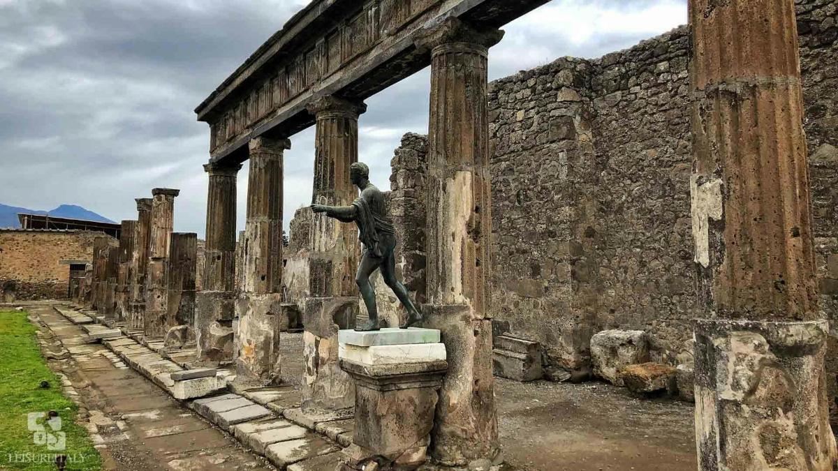 ένα άγαλμα ενός άνδρα που στέκεται πάνω σε μια κολόνα