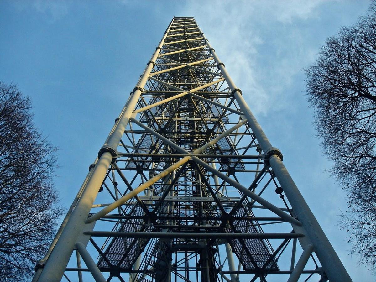 a tall metal tower with a blue sky in the background