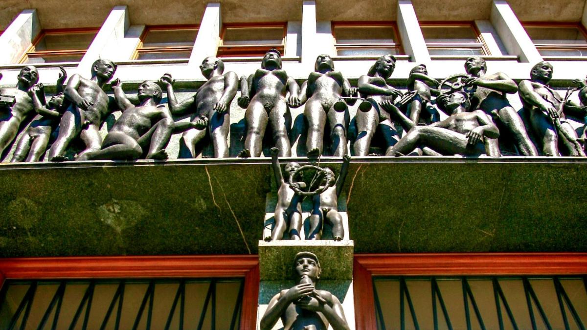 uma estátua de homens na lateral de um prédio