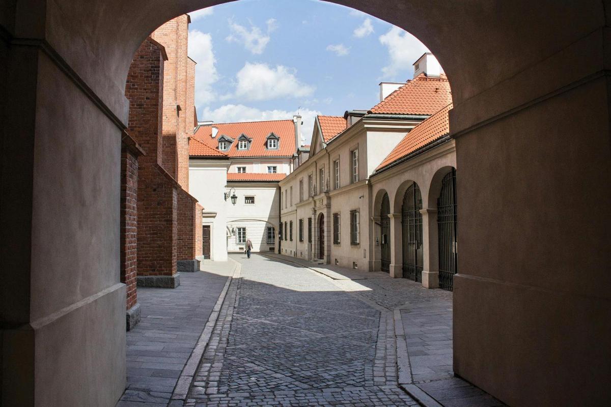 an alley with an archway in a city