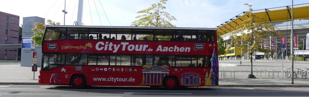 a red double decker bus driving down a street