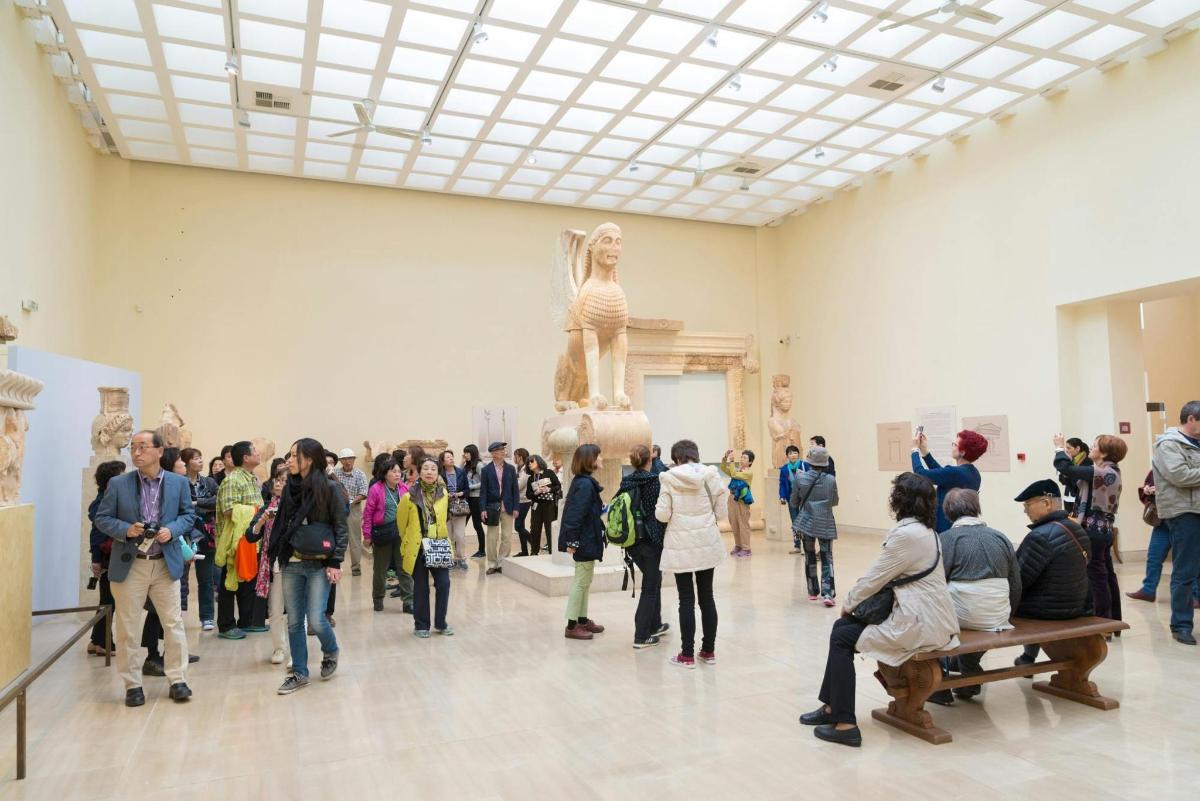 Una multitud de personas mirando una escultura en un museo.