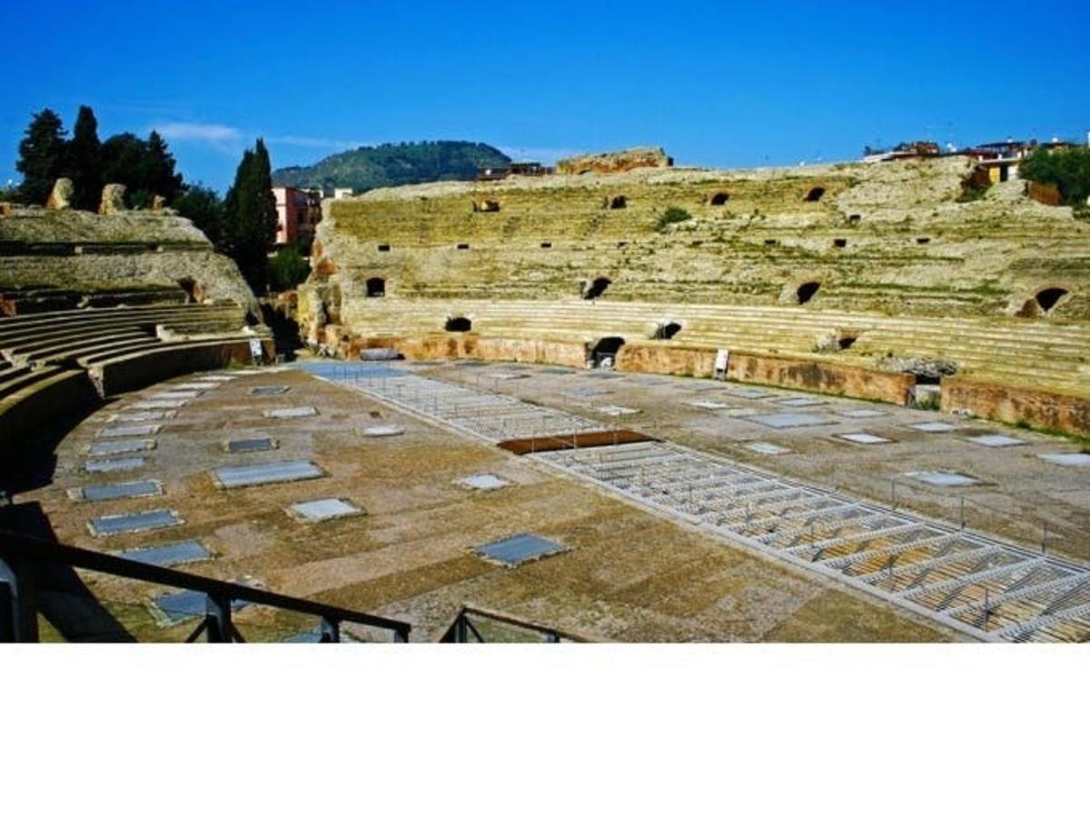 un anfiteatro vuoto con un cielo azzurro sullo sfondo