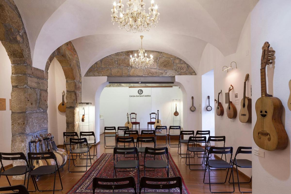 a room with a bunch of chairs and guitars