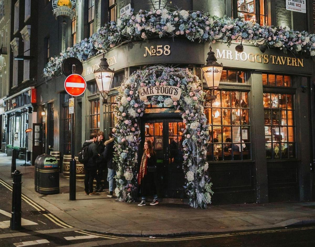 Una fachada de una tienda con un arreglo floral.