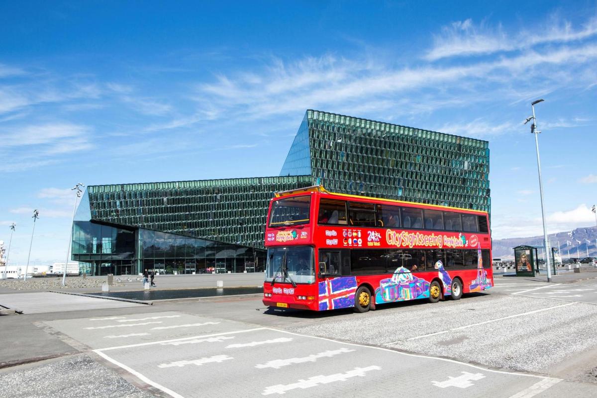 a red double decker bus parked in front of a building