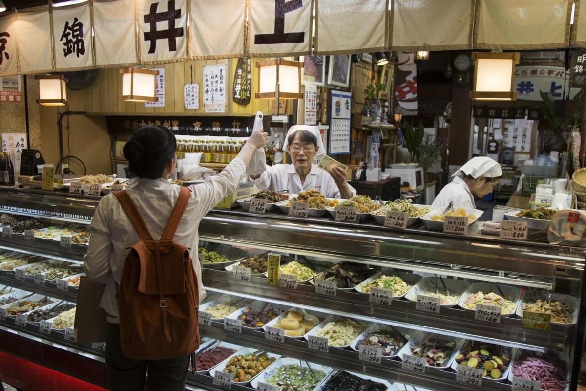 two people standing in front of a food counter