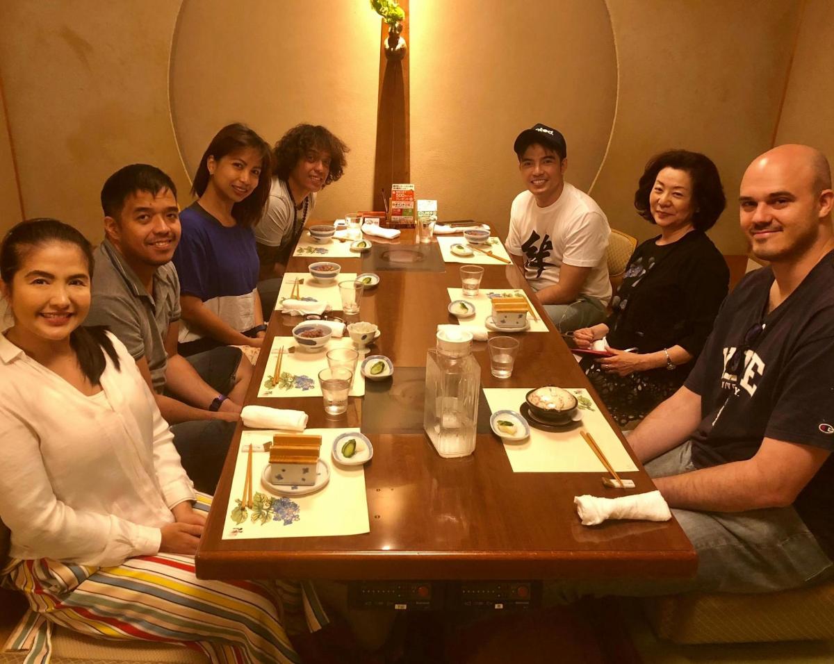 a group of people sitting around a wooden table