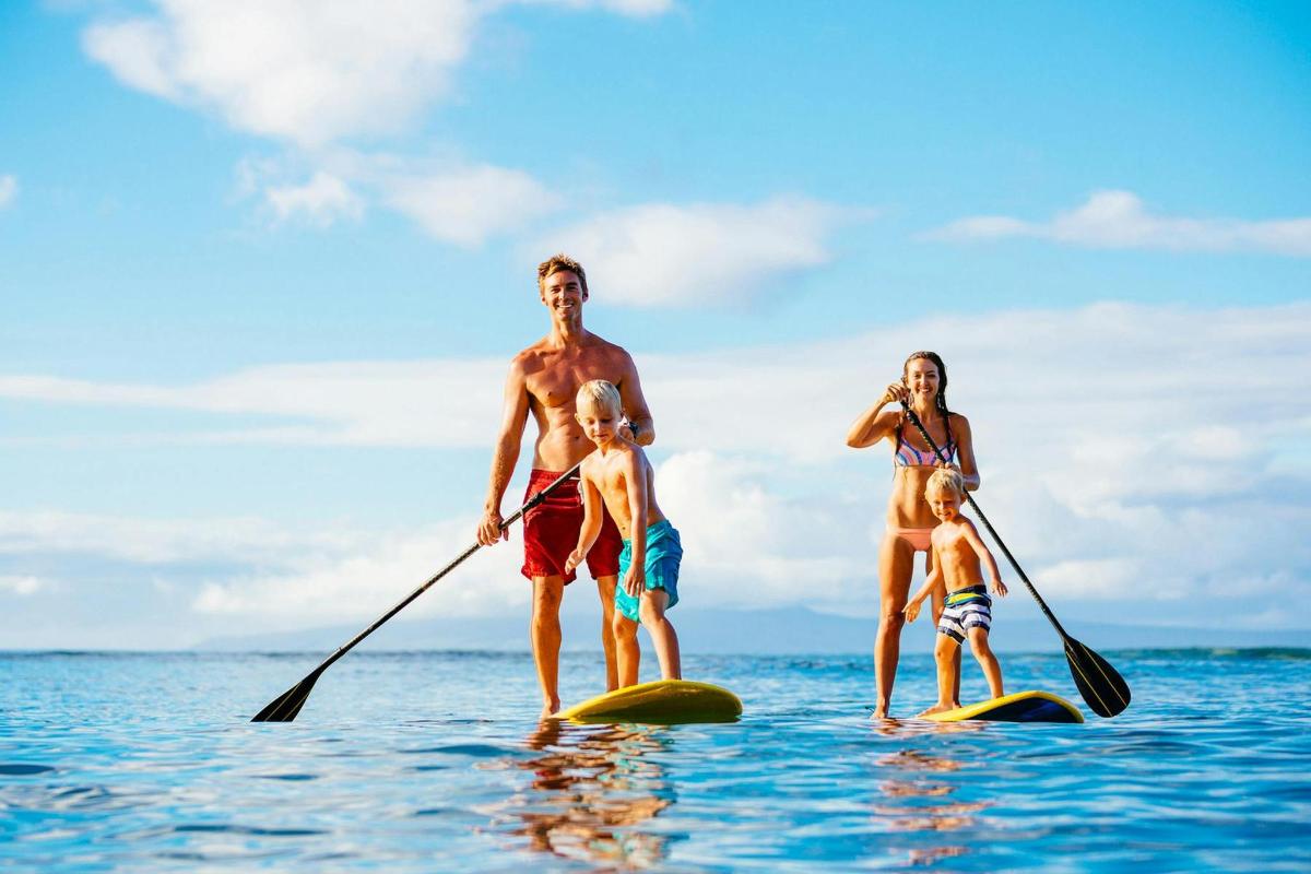 muž, žena a dítě na paddleboardech ve vodě