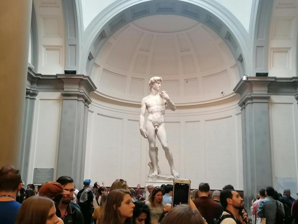 cilvēku pūlis, kas muzejā aplūko statuju
