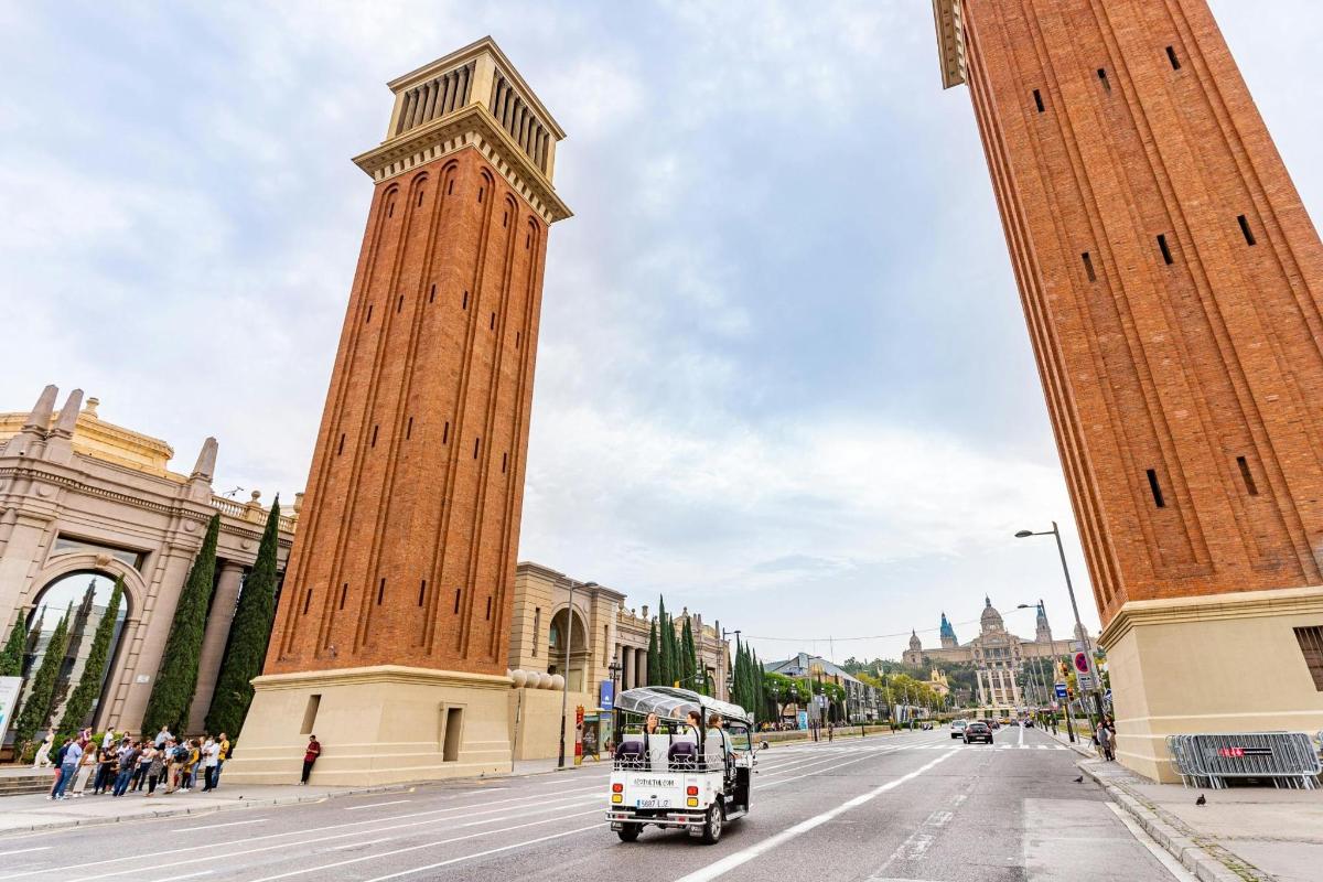 un camió circulant per un carrer amb una torre de rellotge alta