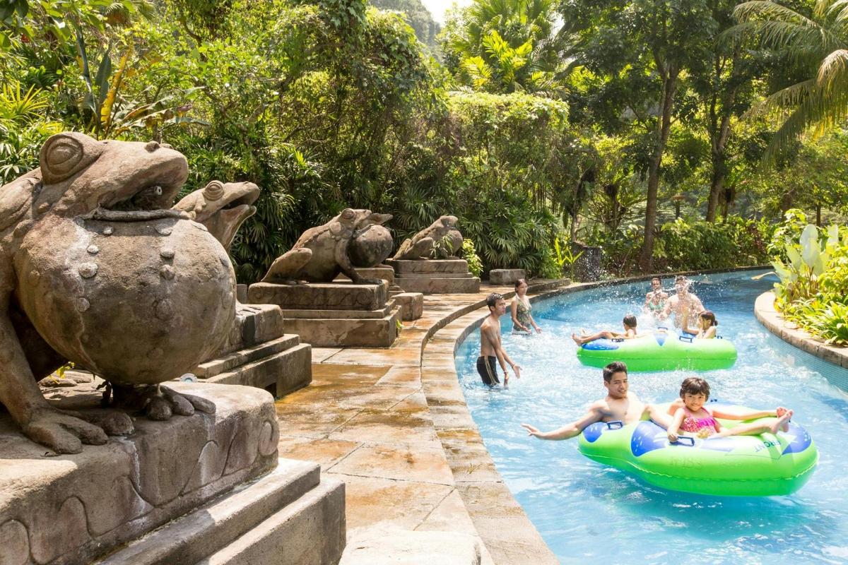 a group of people in inflatable tubes in a pool at a resort