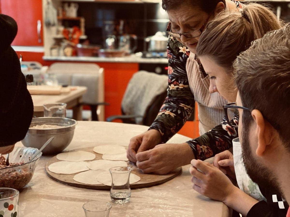 uma mulher está fazendo uma pizza em uma mesa