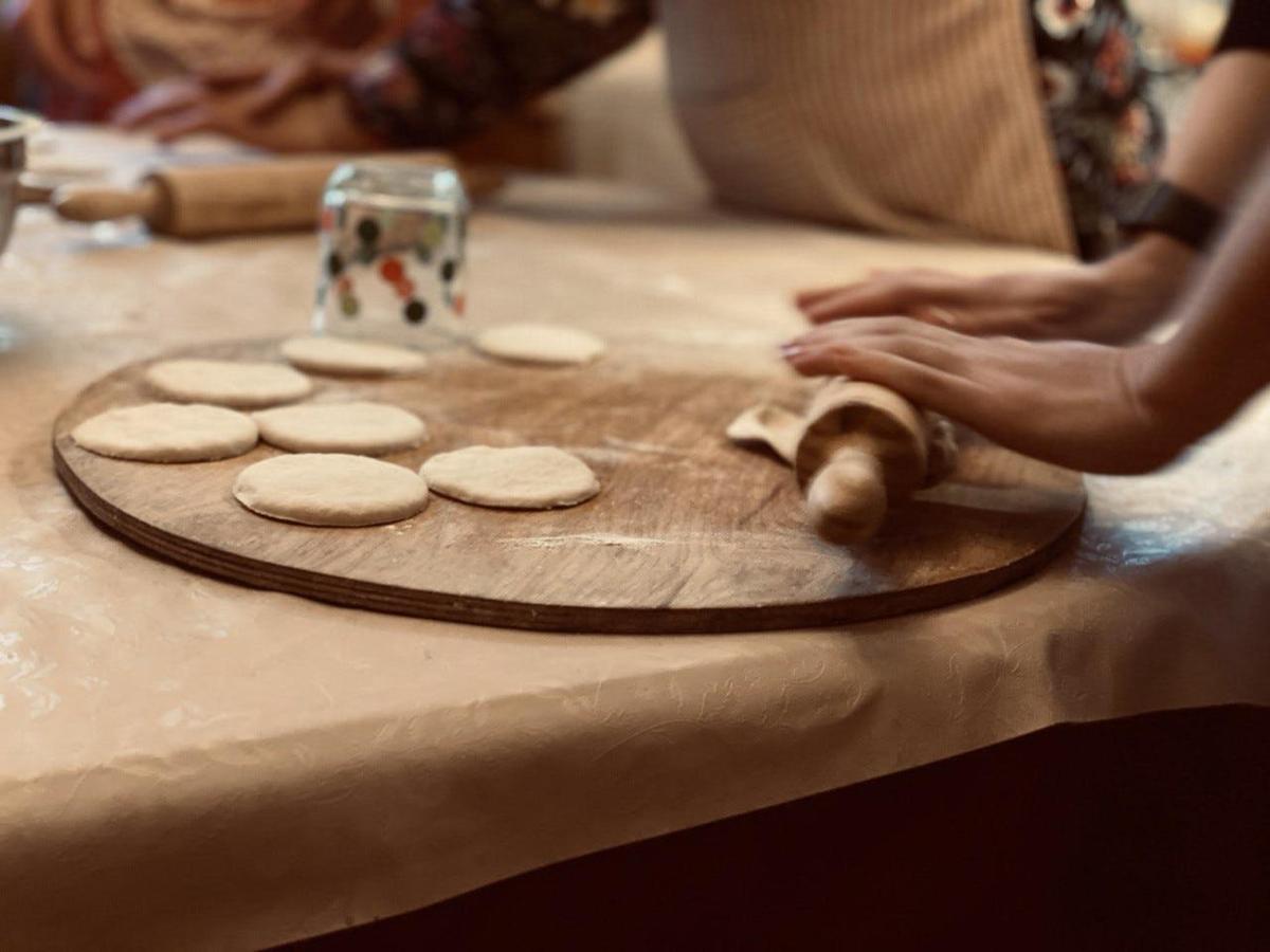 isang taong gumagawa ng cookies sa isang cutting board sa isang mesa