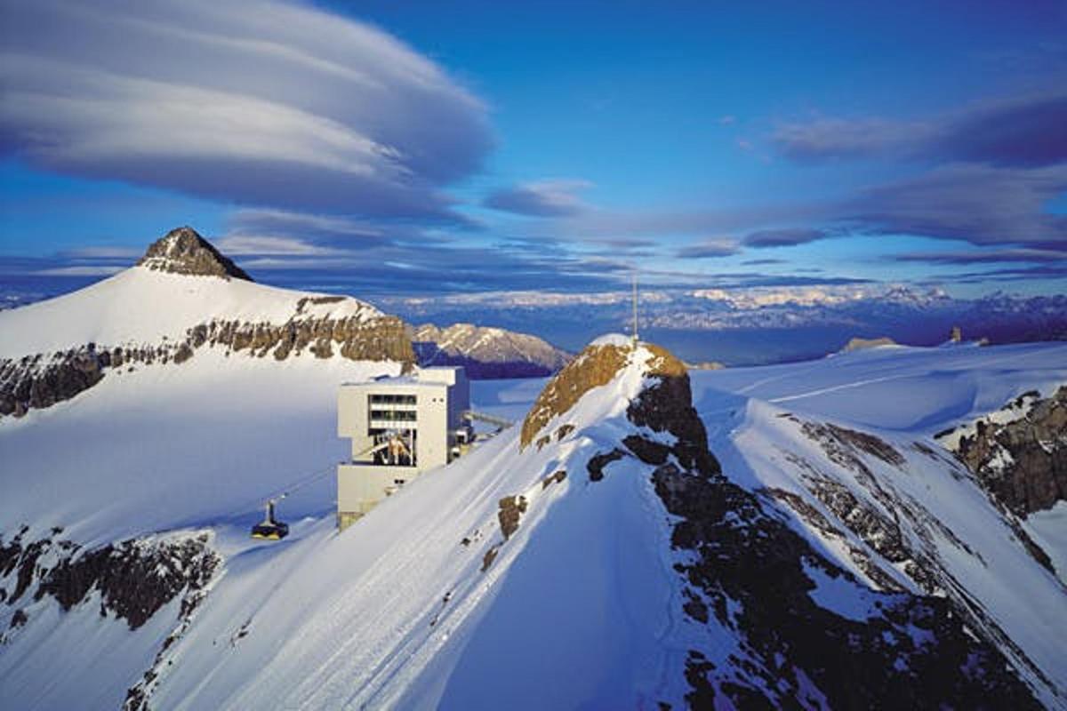 a snow covered mountain with a building on top of it