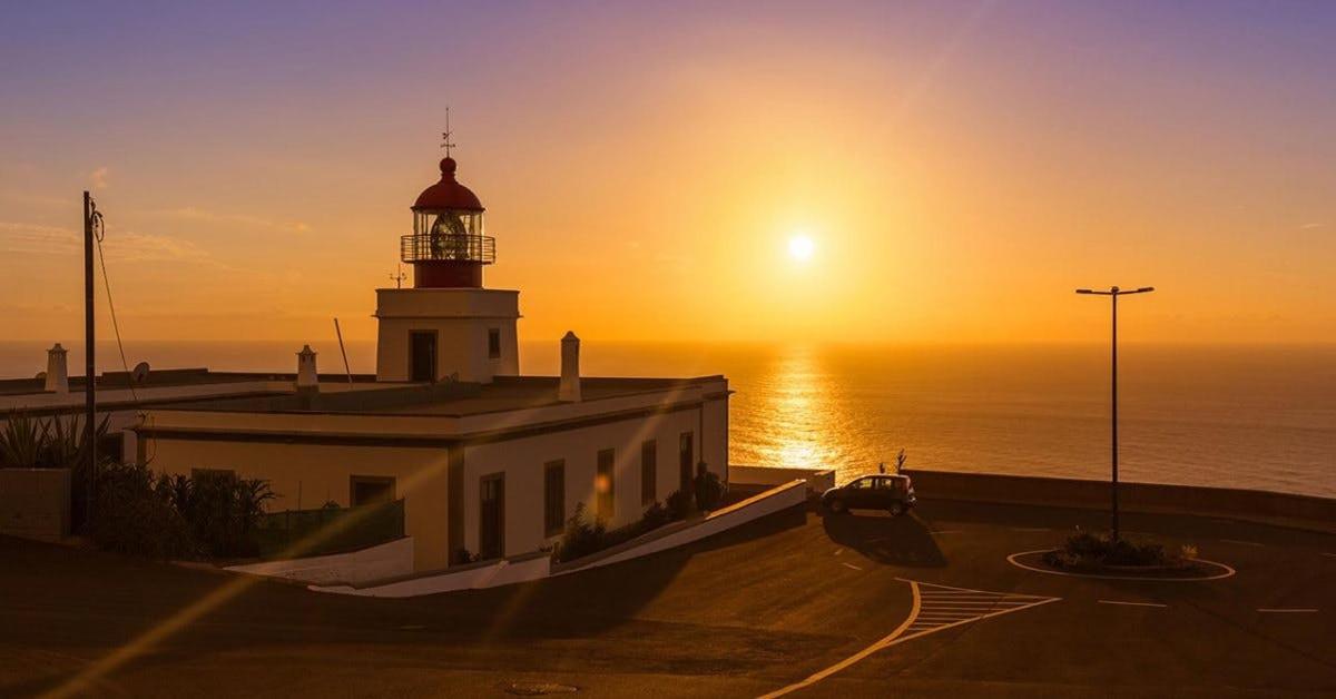 ein Leuchtturm mit dem Sonnenuntergang im Hintergrund