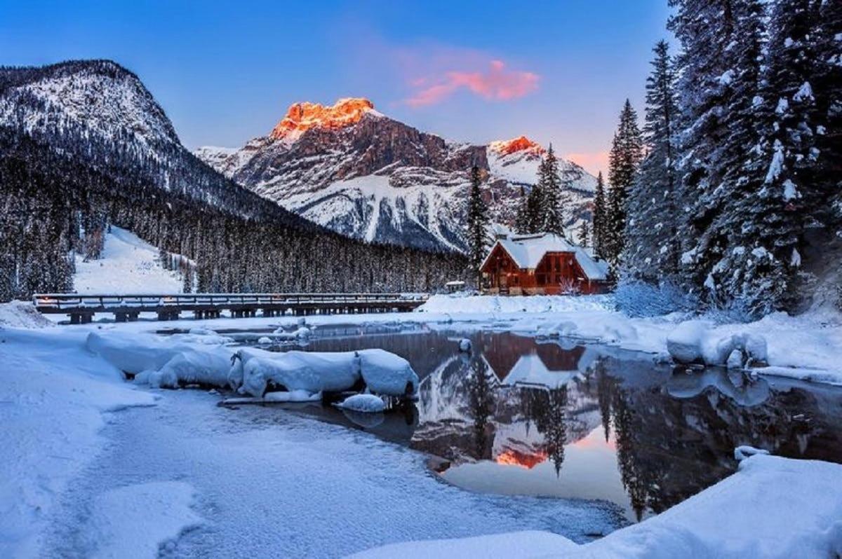 una escena hivernal d'una estació de tren i una muntanya