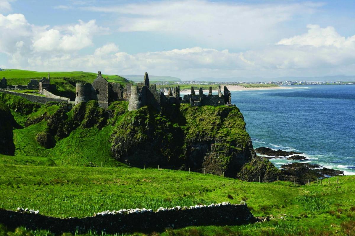 a castle on a hill next to the ocean