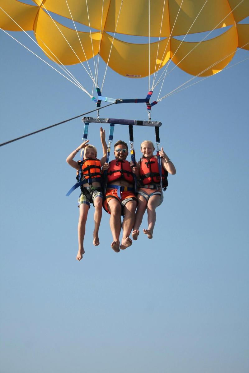 a group of three people riding on a parachute