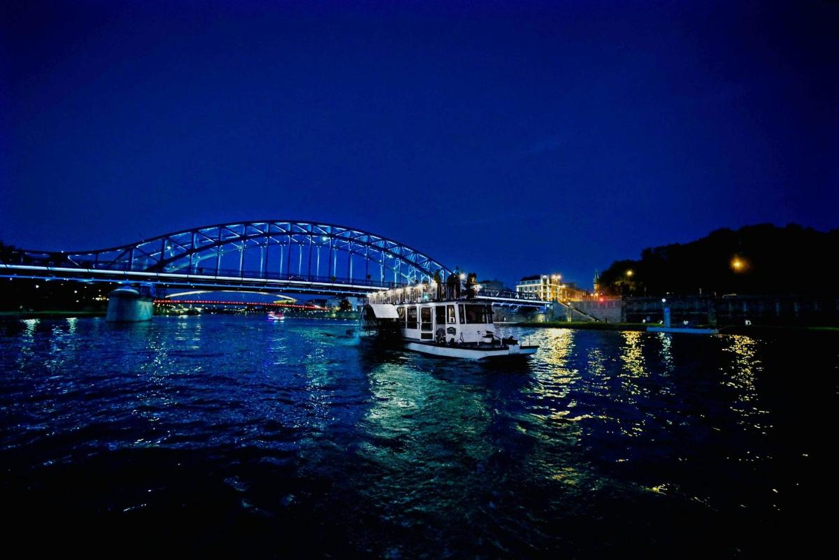 a boat in the water near a bridge at night
