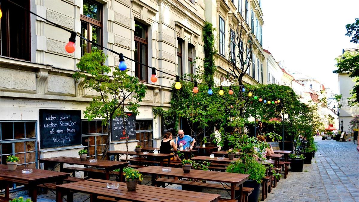 dva lidé sedící u stolů před restaurací