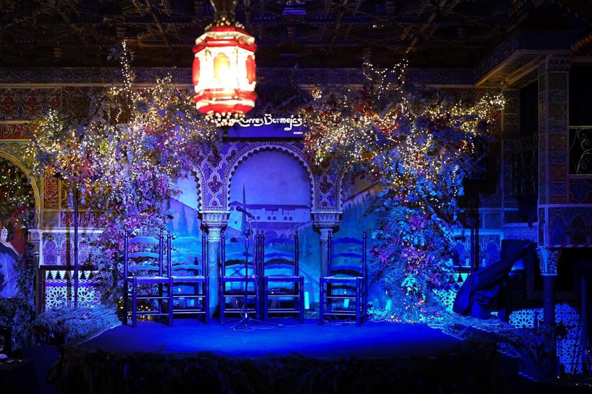 isang entablado na may mga upuan at christmas lights sa isang silid