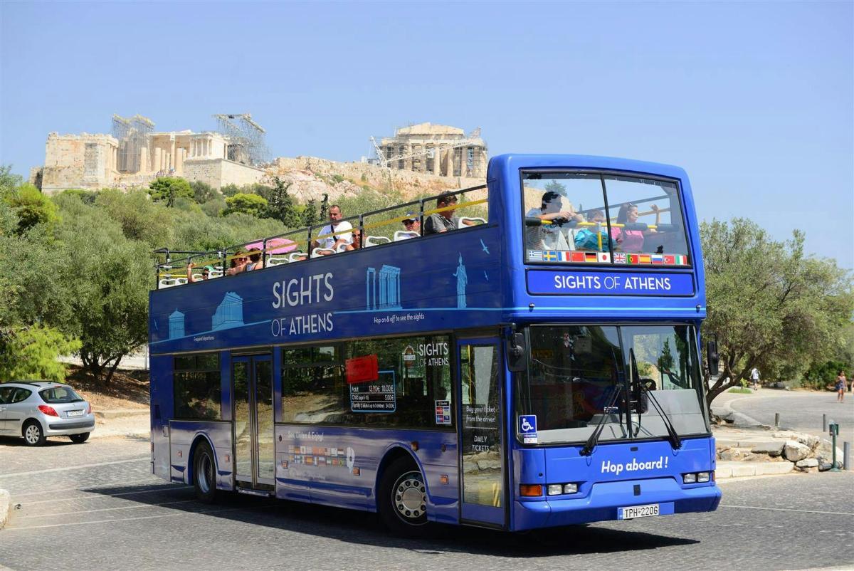 a blue double decker bus driving down a street