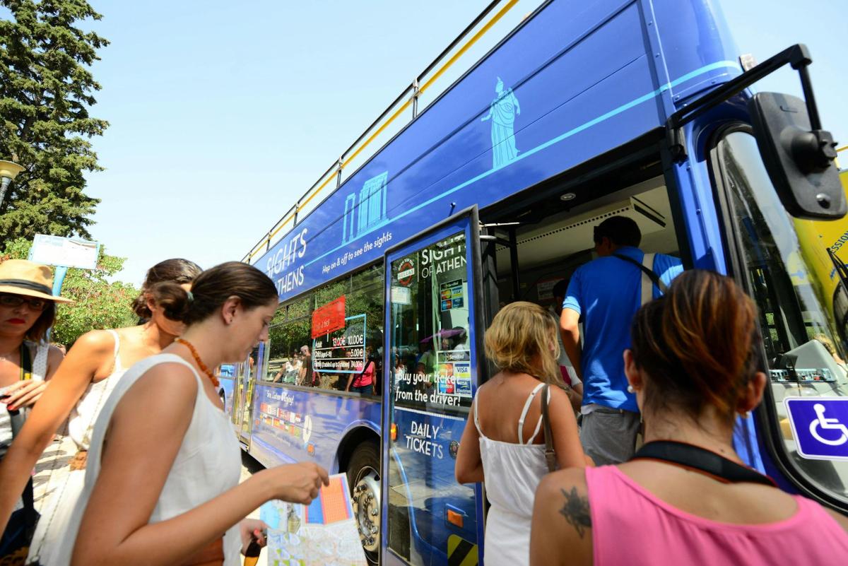 skupina lidí stojících před autobusem