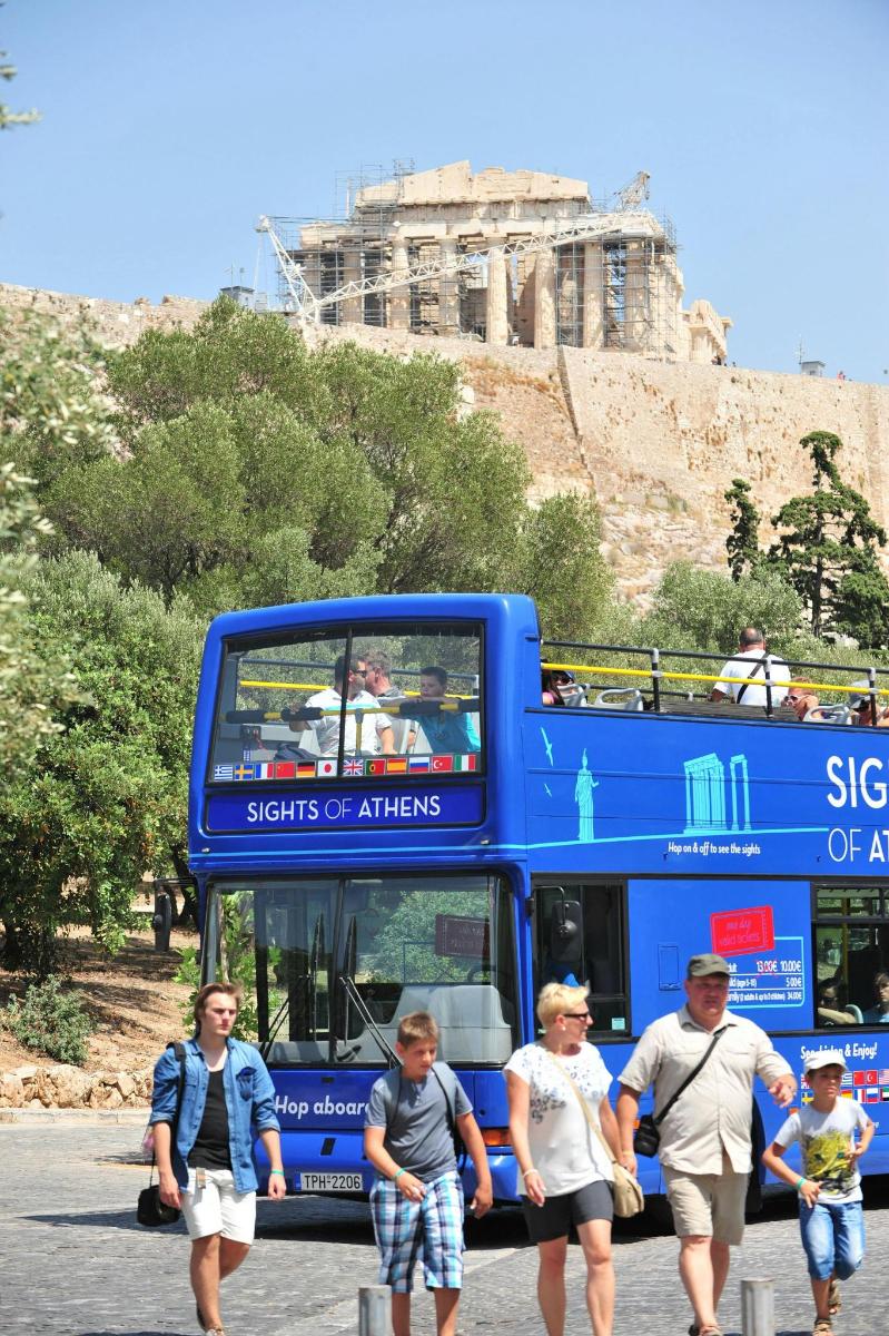 un autobus blu a due piani con persone che camminano davanti