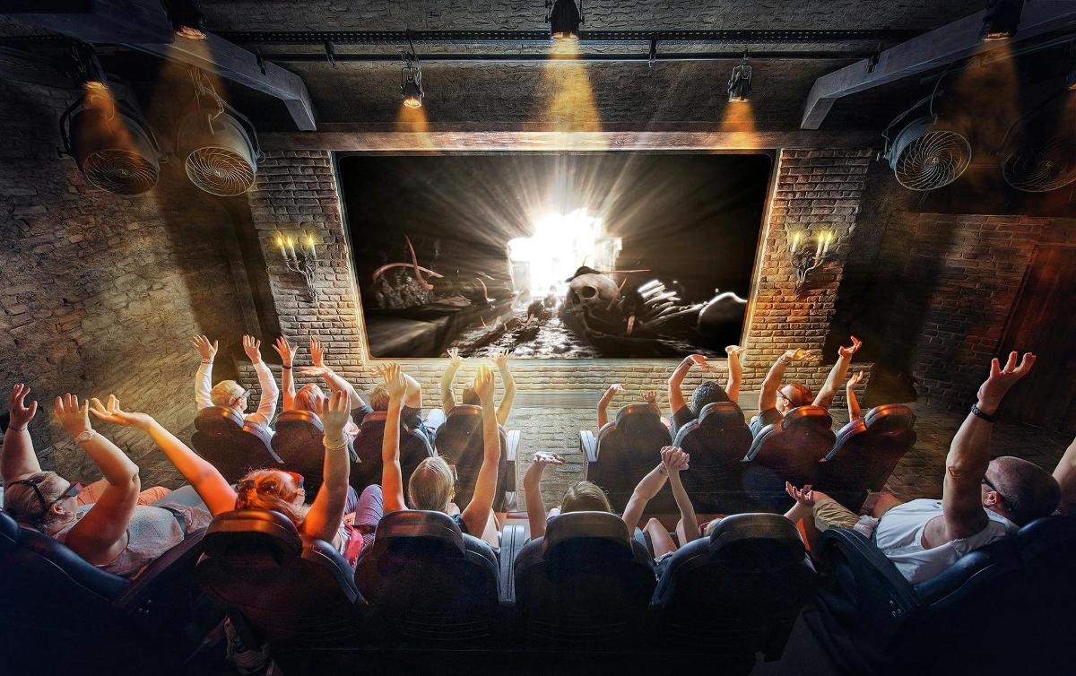 un pubblico in un teatro con le mani alzate