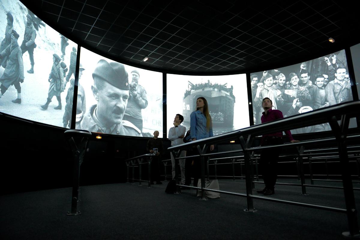 a group of people standing in front of a large screen