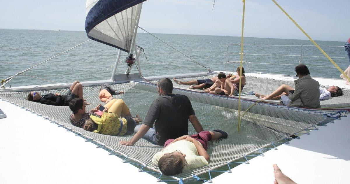 skupina ljudi, ki ležijo v vodi na čolnu