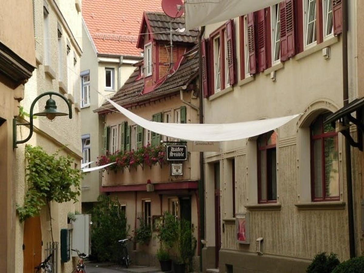 an alley with buildings with a white cloth hanging over it