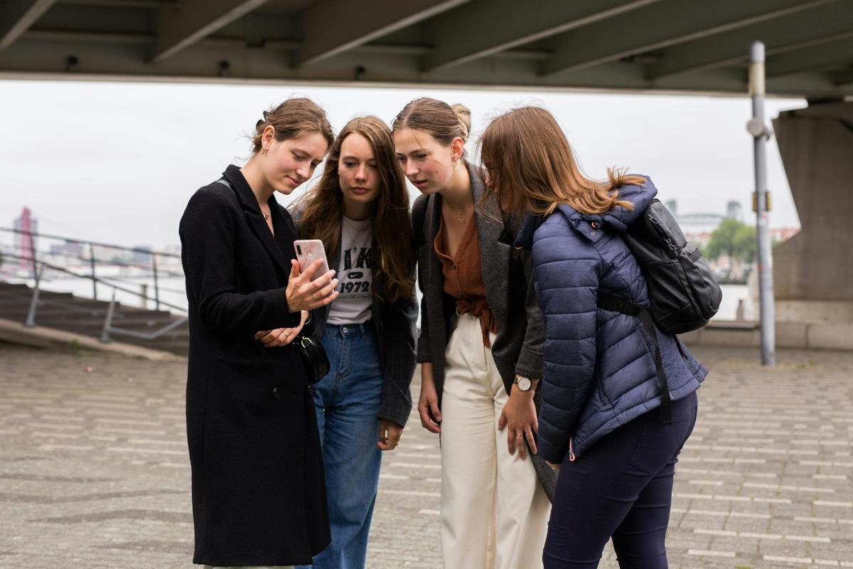 un gruppo di tre ragazze che guardano un cellulare