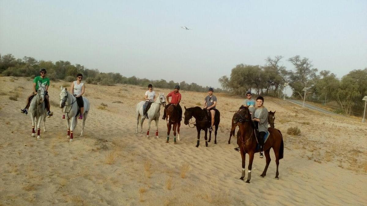 a group of people riding horses in the desert