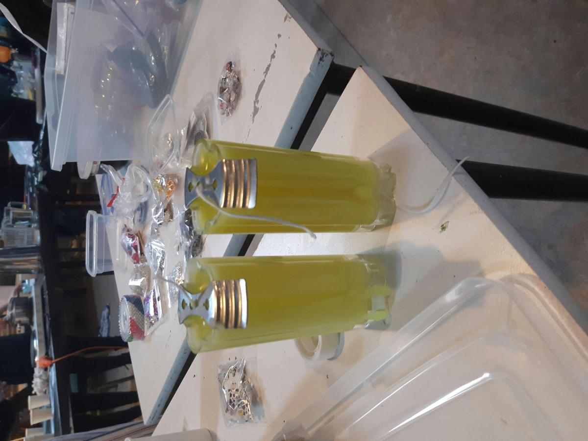 duas garrafas amarelas estão penduradas em uma mesa
